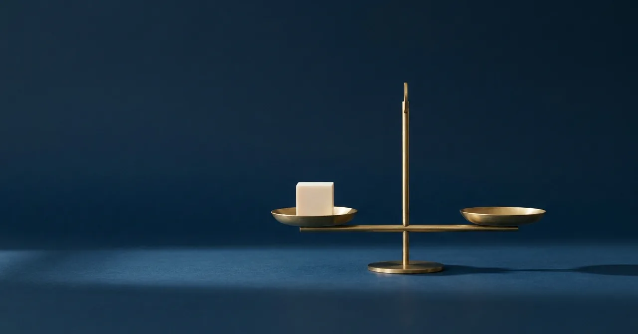 Balance en laiton en parfait équilibre sur une surface bleu marine, un cube blanc dans l'un des plateaux.