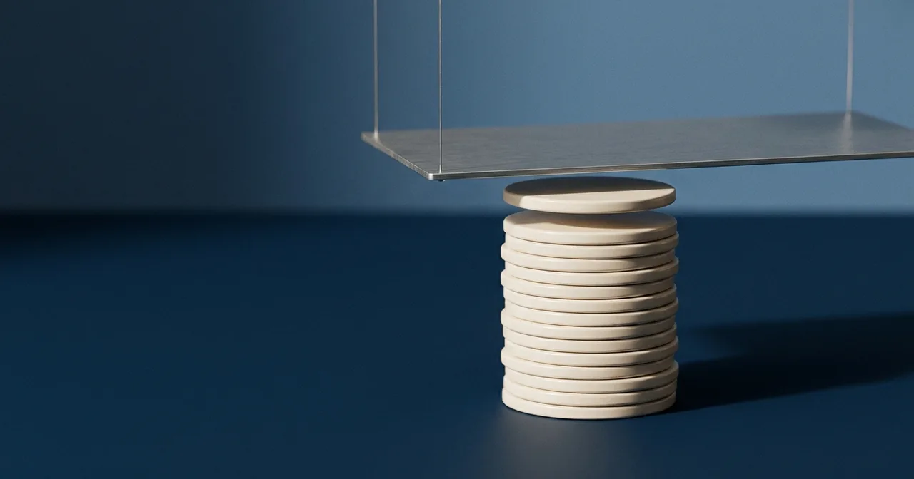 Pile de disques crème s'élevant vers une plaque d'acier suspendue, le disque supérieur l'effleurant presque.